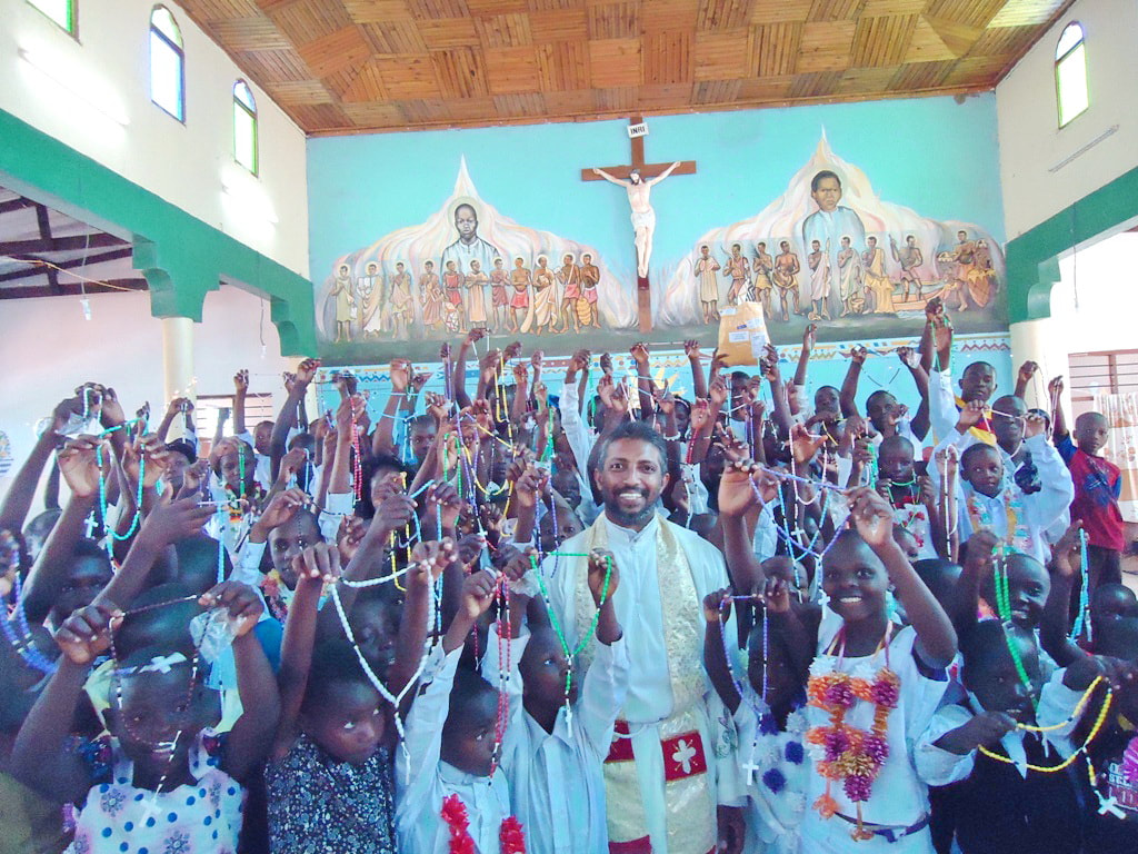 Fr Santhosh with children in Tanzania