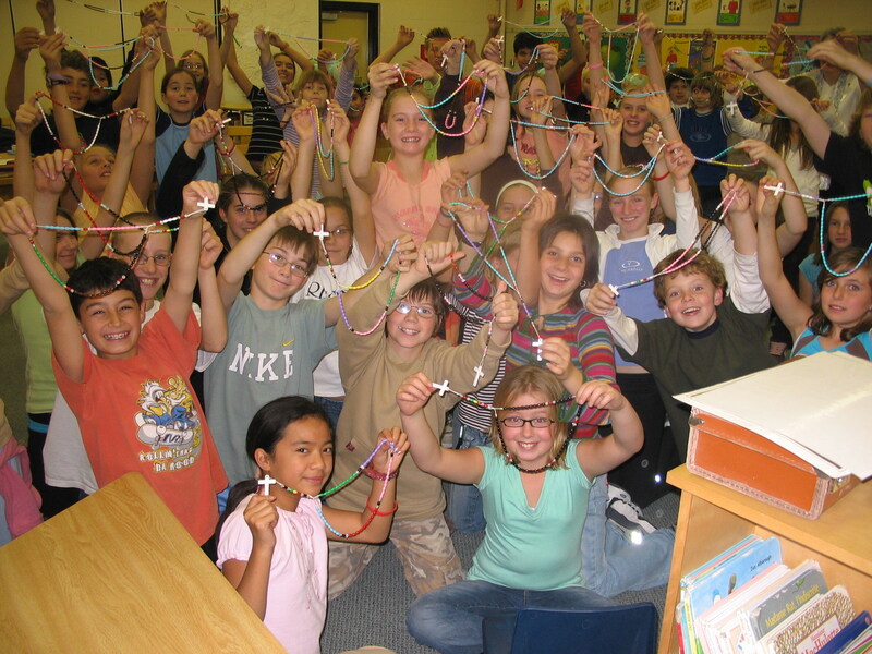 Students in one of our Calgary schools proudly showing off the rosaries that they made